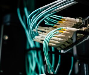 Close-up of fiber optic cables connected to a network switch, representing field operations in fiber installation.